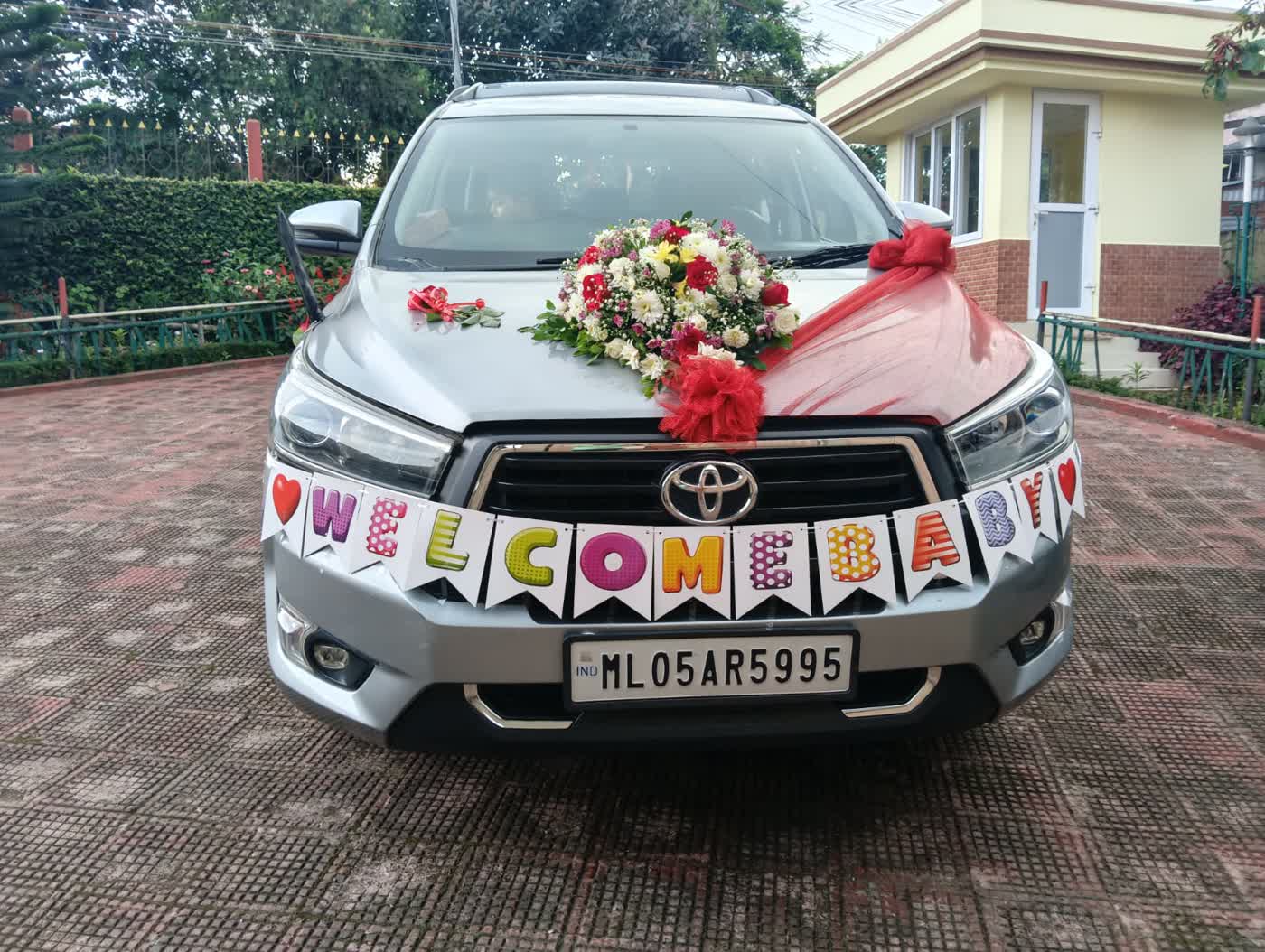 A Toyota Innova Crysta decorated with flowers for a family welcome in Shillong